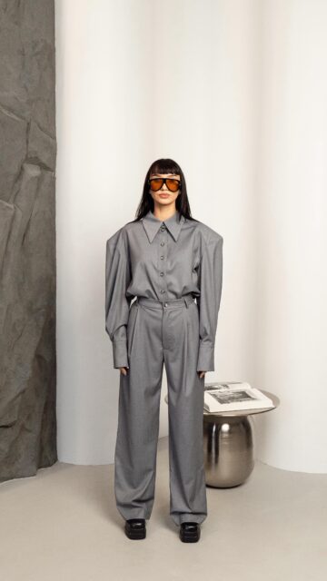 MONUMENTAL kostiumėliai – architektūrinė drąsa, perkelta į audinį.

Išraiškingi marškinių pečiai ir griežta apykaklė sukuria monumentalią liniją, kuri nėra tik detalė, o viso įvaizdžio ašis 🫷

Minimalistinis siluetas įgauna jėgos per formą, o juoda ar pilka spalva pabrėžia jų universalumą – nuo kasdienio miesto ritmo iki išskirtinio vakarienės akcento 🍷 Tai marškiniai, kurie nekalba garsiai, bet palieka neišdildomą įspūdį.

Kelnių linijos, kurios kuria erdvę aplink kūną 🌪️

Jos krinta laisvai ir plačiai – jose dera tvirtumas ir judesio laisvė, todėl įvaizdis tampa solidus bei lengvas. Klostės priekyje įveda ritmą, o juoda ar pilka spalva tampa grynosios formos fonu. Tai ne tik kelnės – tai konstrukcija, kurioje judesys ir rimtis gyvena viename 🔗